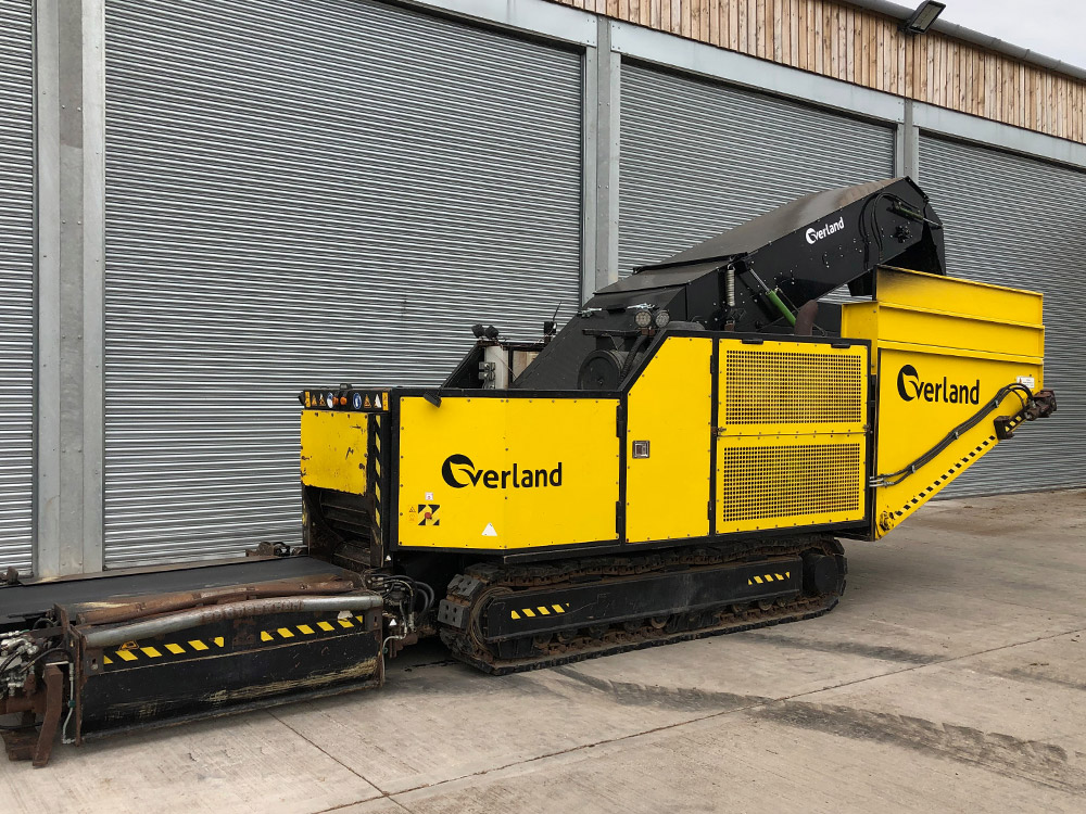 Overland crop rotation machine parked outside a warehouse